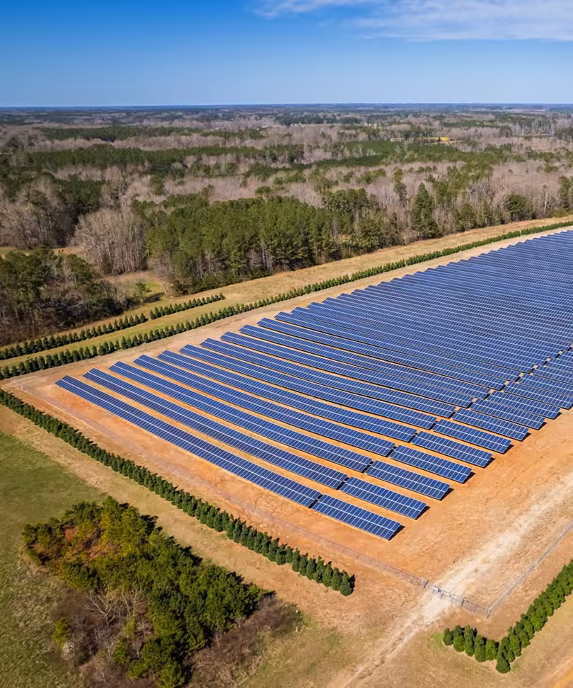 Aerial view of a solar plant site beside woodland
